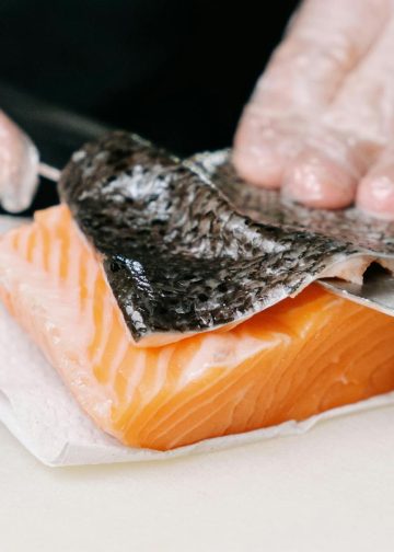 A Person Removing the Skin of a Salmon